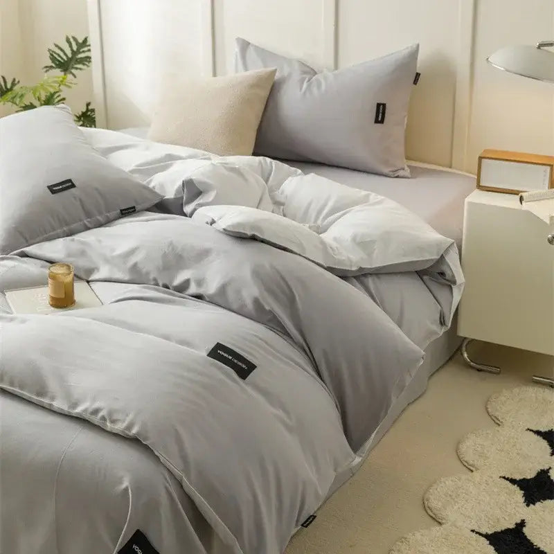 Gray duvet bedding set with plush fabric and subtle black label accents in a minimalist off-white and mint matching cotton set