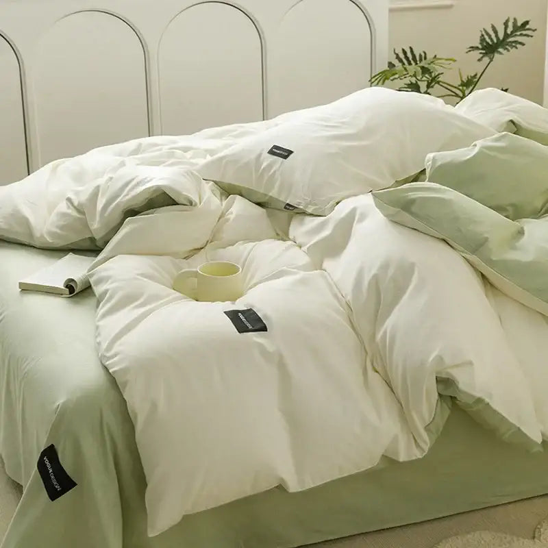 Minimalist off-white and mint matching cotton bedding set with soft white and pale green duvet featuring subtle texture and black tags