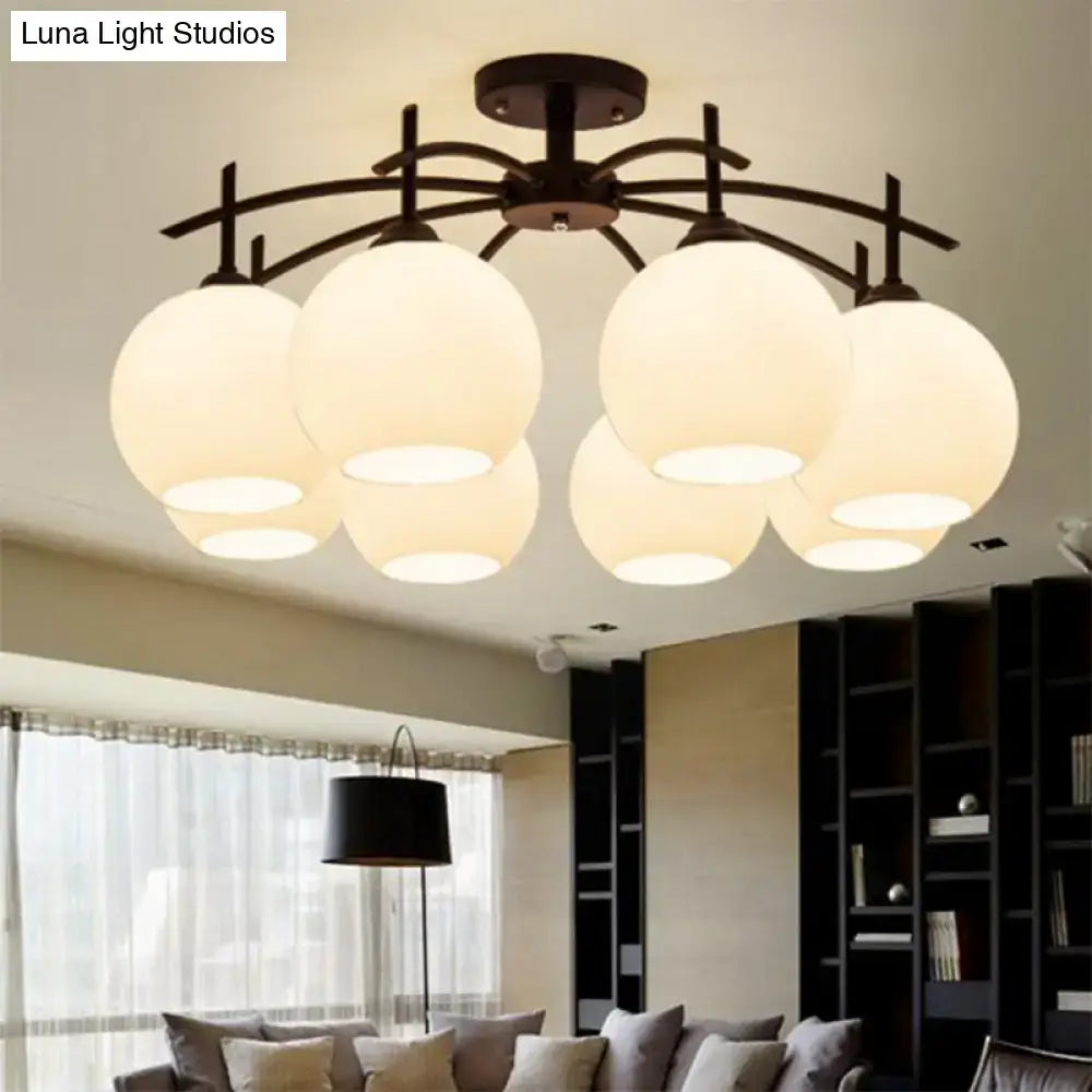 Modern black metal chandelier with six frosted opal glass globes suitable as a living room ceiling light