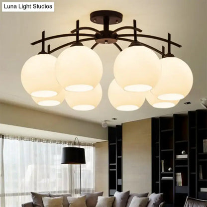 Modern black metal chandelier with six frosted opal glass globes suitable as a living room ceiling light