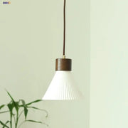 Minimalist pendant light fixture with white pleated glass shade and dark wood-finished metal collar for kitchen use