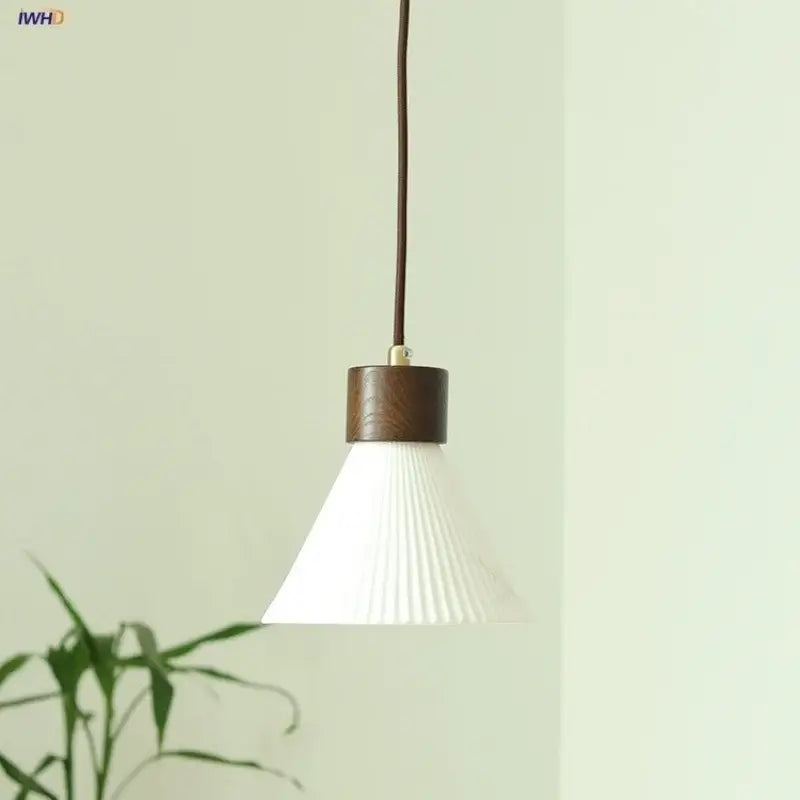 Minimalist pendant light fixture with white pleated glass shade and dark wood-finished metal collar for kitchen use
