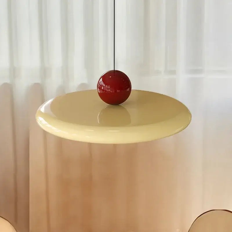 A minimalist red cream iron art pendant light hangs above a pale yellow table for bedroom decorbites cream iron use