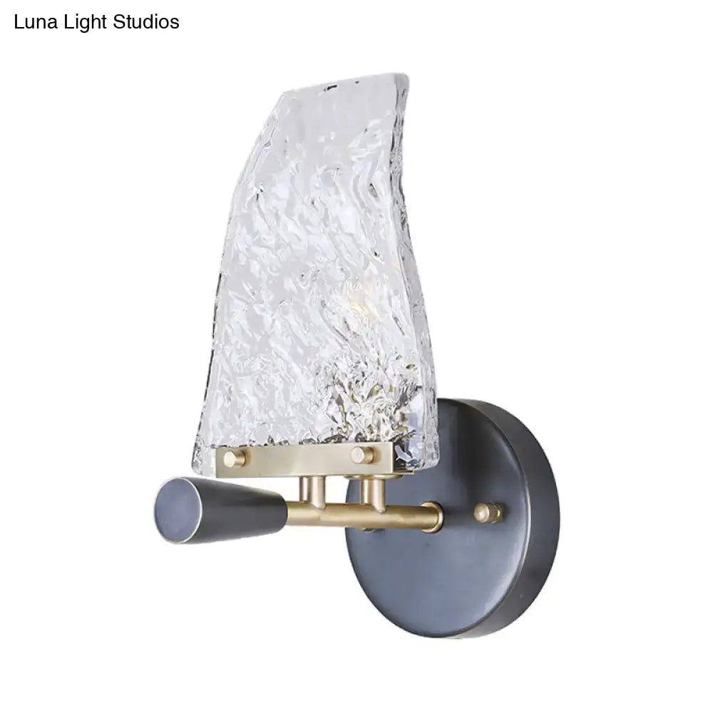 A minimalist sail glass wall light with a textured translucent shade, brass accents, and matte black base for bedroom use