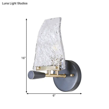 Minimalist sail glass wall light with textured clear glass shade brass accents and matte black base for bedroom use