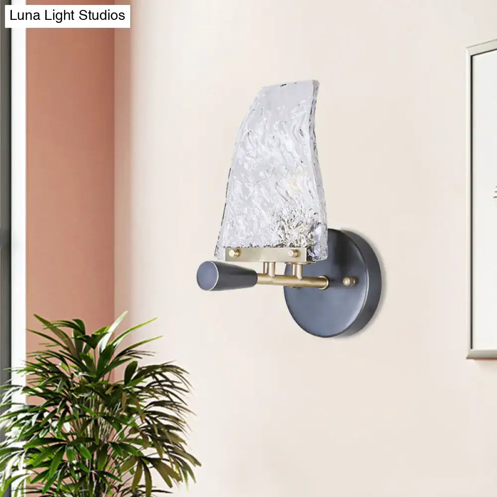 Minimalist black and brass wall light with textured translucent glass shade for bedroom lighting and decor