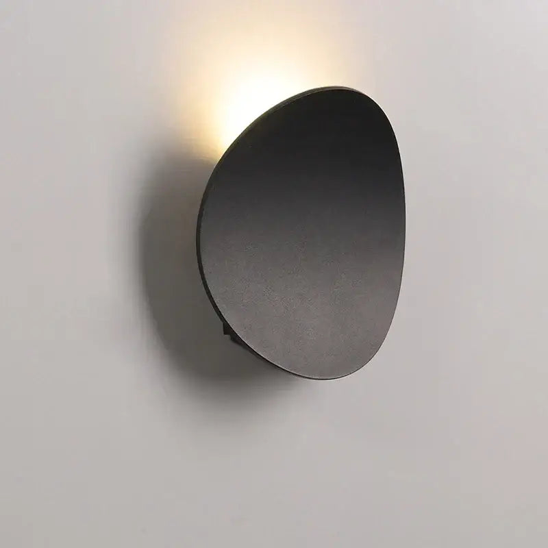 Minimalist silver and black led wall lamp with modern matte black oval wall sconce and warm focused light beam