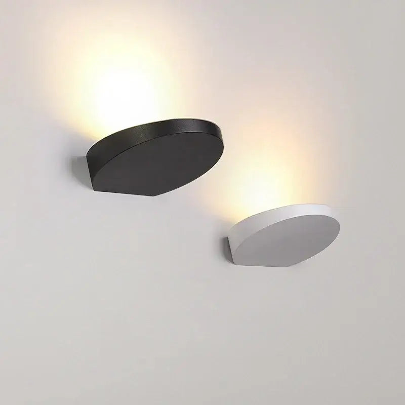 Minimalist silver and black led wall lamp with sleek curved design and warm ambient lighting for bedroom use