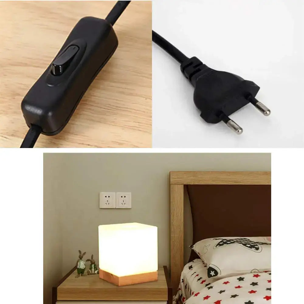 Black plastic toggle switch with integrated cord and european plug beside glowing white cube glass ball table lamp decorbites bedroom light