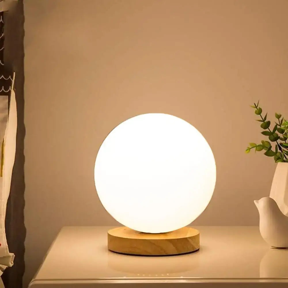 Minimalist sphere and cube glass ball table lamp with a glowing white glass ball and wooden base for bedroom decorbites light