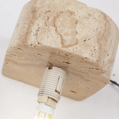 Beige stone lamp base with textured natural surface and integrated led bulb in minimalist decorbites glass lampshade wall light