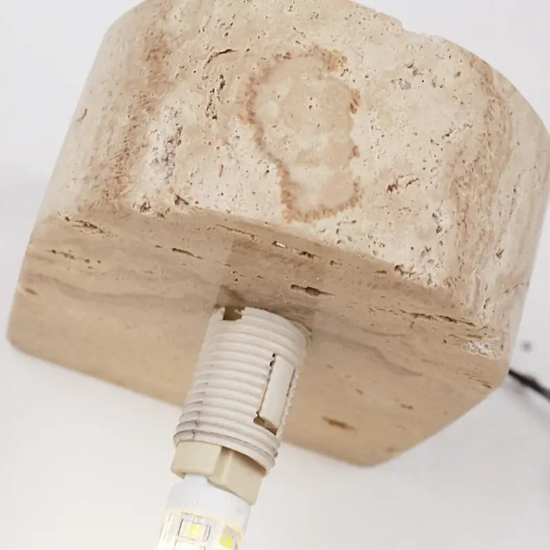 Beige stone lamp base with textured natural surface and integrated led bulb in minimalist decorbites glass lampshade wall light