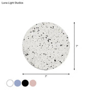 Minimalist terrazzo round led wall sconce with a speckled white and black 7-inch round terrazzo coaster surface