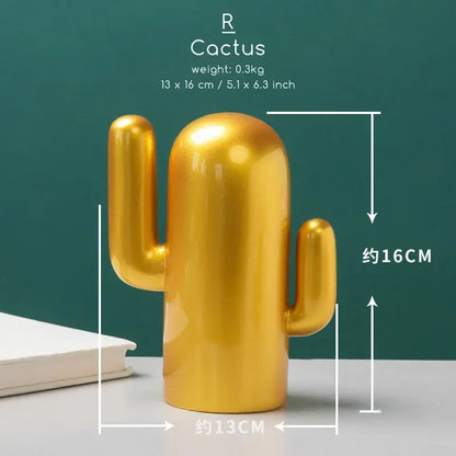 Golden ceramic cactus figurine with glossy finish and two arms paired with minimalist decorbites bird figurine office phone holder