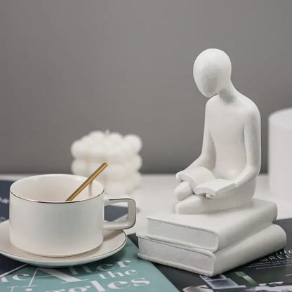 White ceramic minimalist abstract people resin statue of a seated figure reading for decorbites living room decor