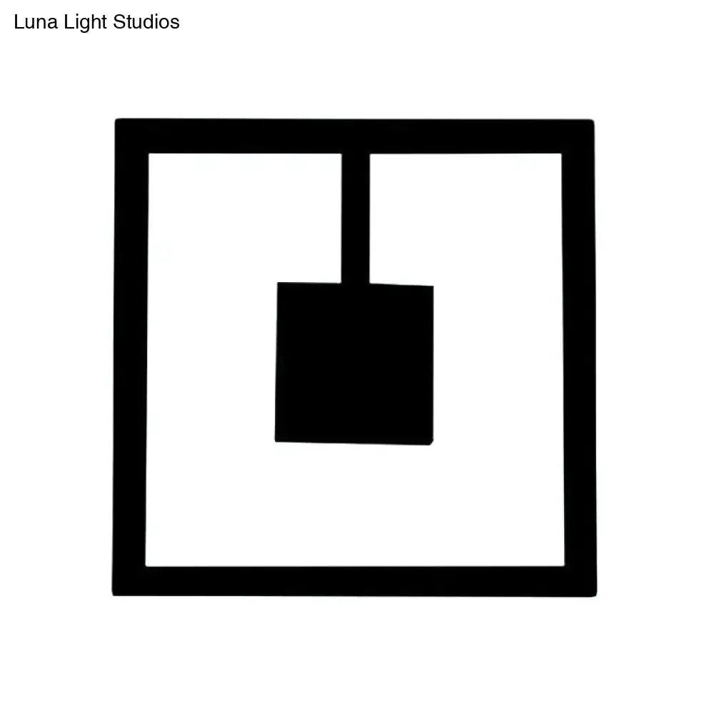 Black silhouette of a shovel inside a minimalist white acrylic wall light fixture with direct wired electric setup