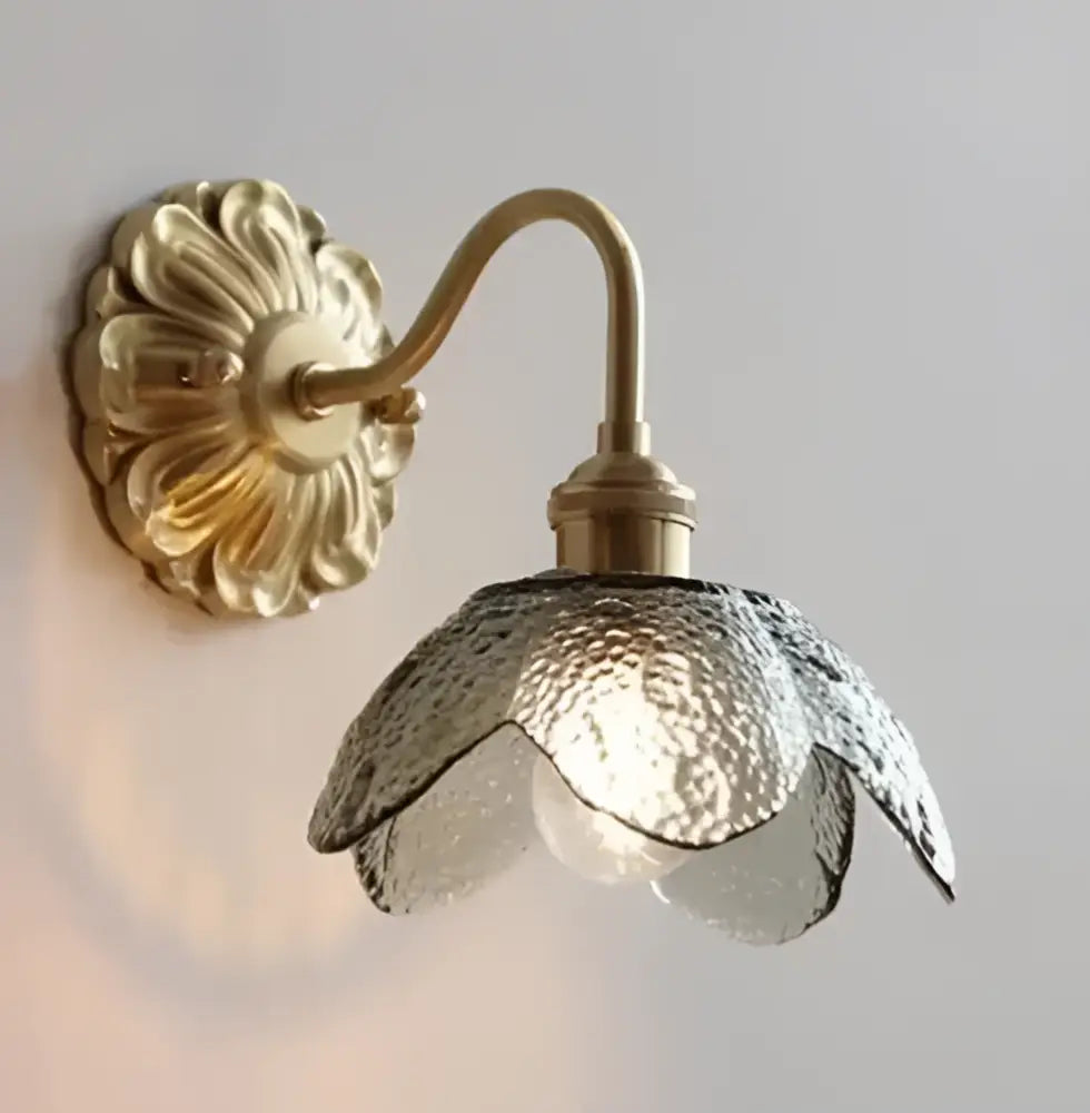 Gold-toned wall sconce with textured translucent glass shade shaped like an open flower for glass pendant light