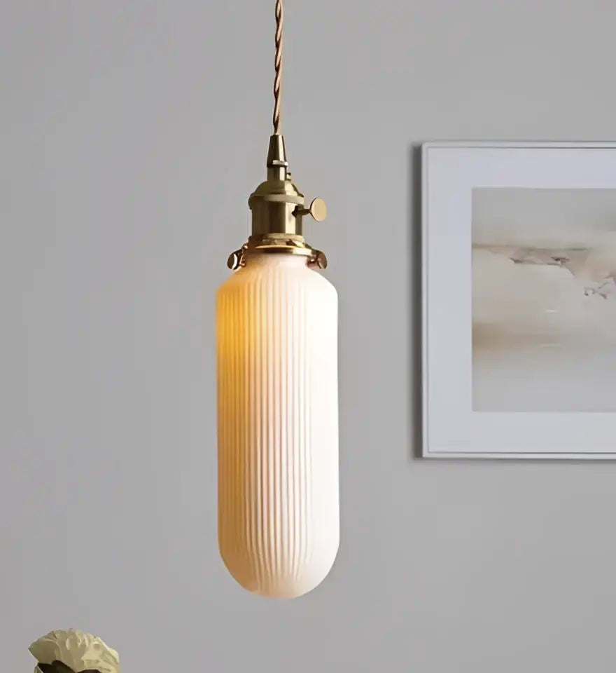 Minimalist warm-toned glass pendant light with ribbed design and brass fixture for bedroom lighting