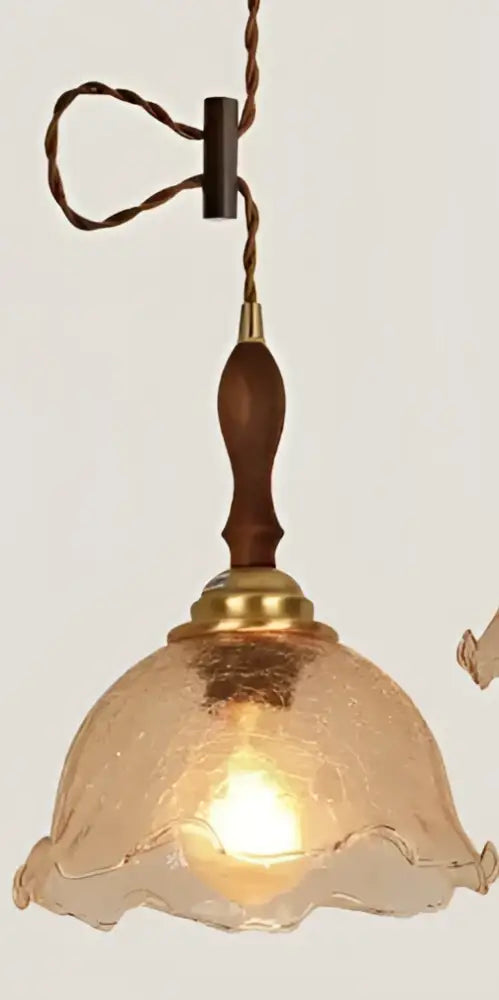 Minimalist white and black glass pendant light with warm-toned textured glass, wooden handle, and brass accents for bedroom