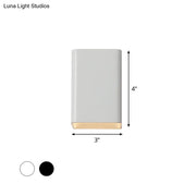 Minimalist wall lamp with a matte white cube shade and warm brass base designed as a sleek bedroom sconce