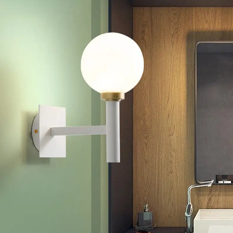 Minimalist white wall lamp with brass accent and opal glass shade mounted on wall for bedroom lighting