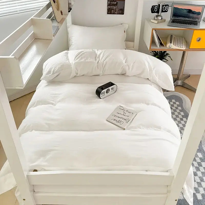 Minimalist white buttoned washed cotton bedding set with plush duvet and matching pillows on a simple bed frame