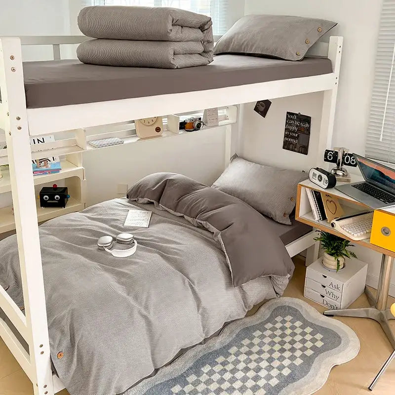 Gray striped bedding set with matching pillowcases and folded blanket on top bunk made of decorbites buttoned washed cotton