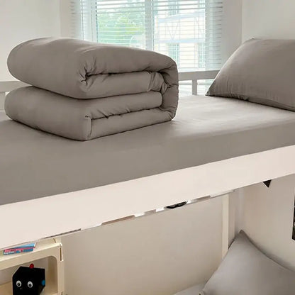 Neatly folded gray duvet cover set made of buttoned washed cotton bedding set by decorbites resting on a bed