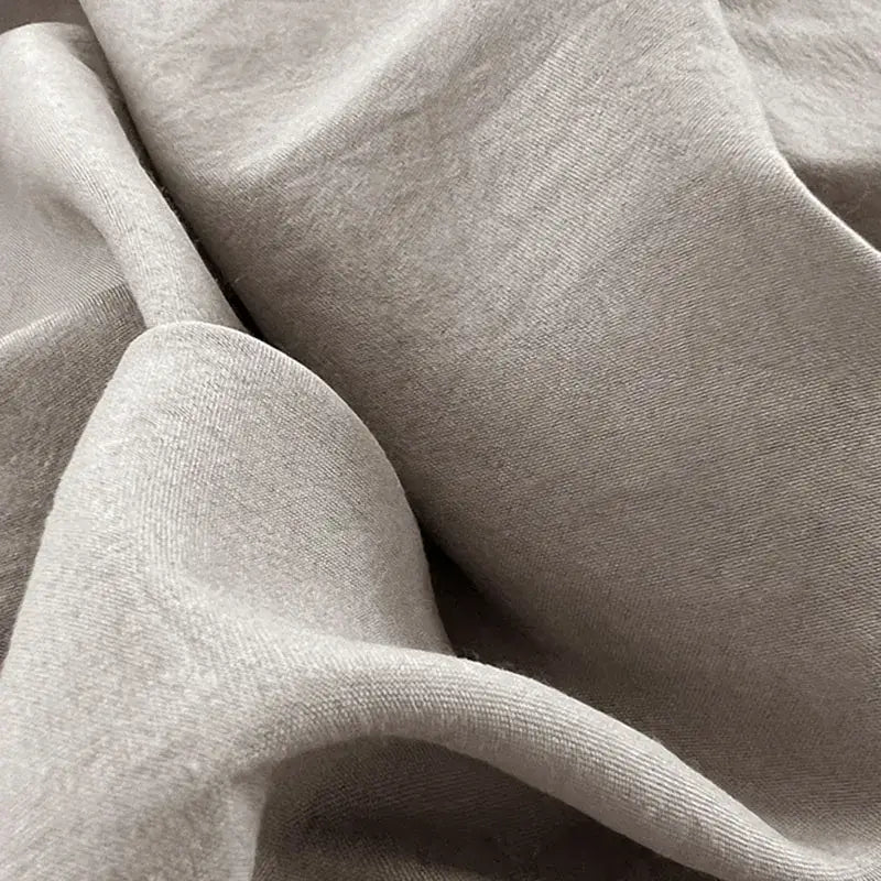 Soft heather gray knit fabric with subtle texture and folds in minimalist white buttoned washed cotton bedding set decorbites