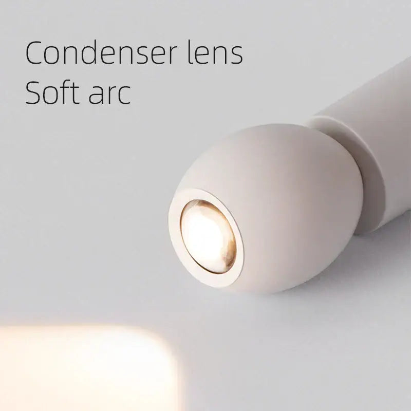 Minimalist white ceramic egg adjustable pendant light with off-white condenser lens and warm-toned spotlight decorbites pendant light