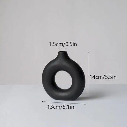 Black matte decorbites ceramic donut vase with a distinctive ring-shaped body and narrow neck for minimalist white decor