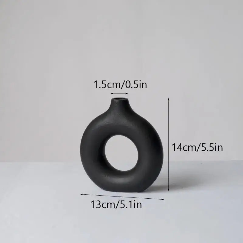 Black matte decorbites ceramic donut vase with a distinctive ring-shaped body and narrow neck for minimalist white decor