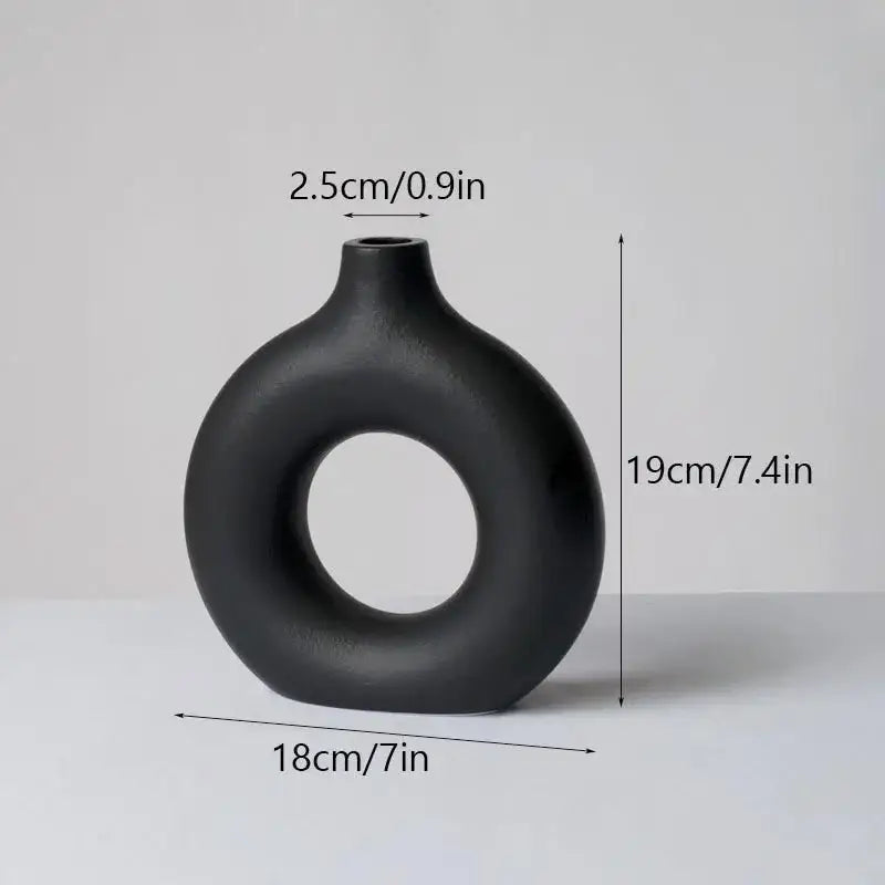 A sleek matte black ceramic donut vase by decorbites with modern ring design and smooth rounded contours for minimalist decor