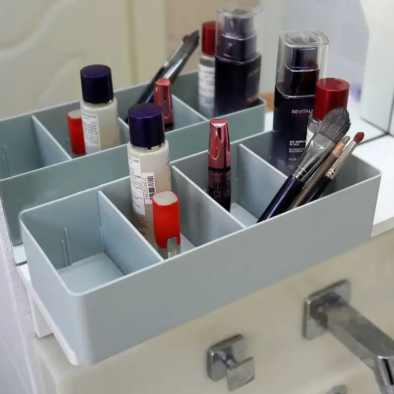 Light blue plastic divided storage box with multiple compartments for makeup and brushes organizer