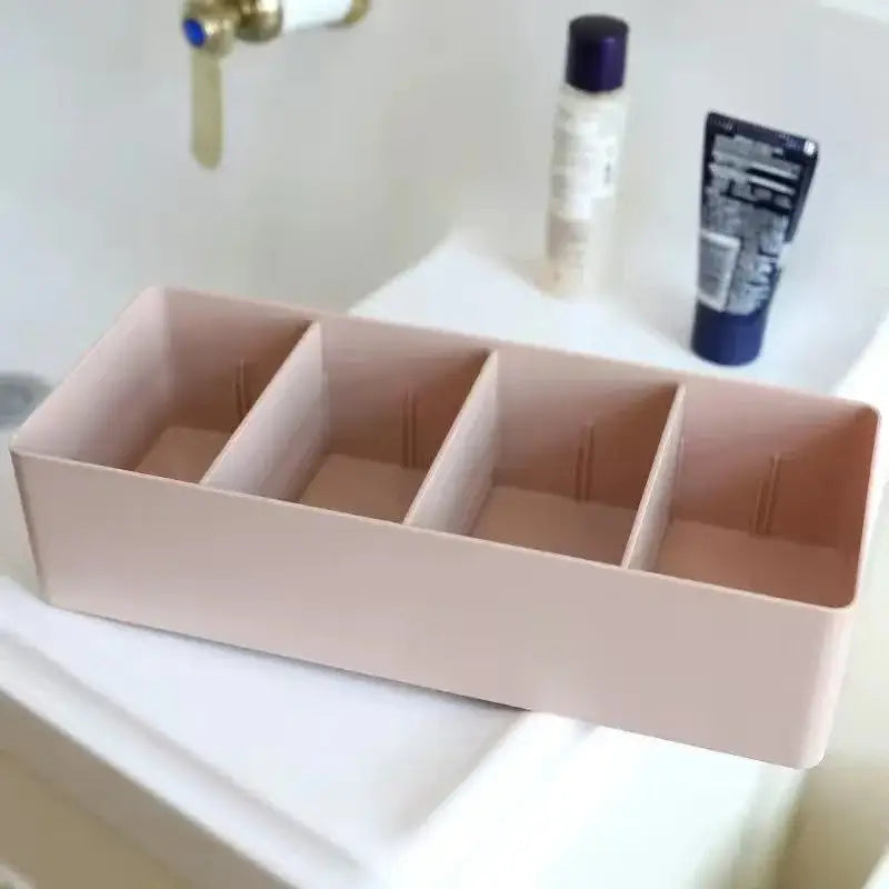 Beige plastic minimalist divided storage box with four rectangular compartments for kitchen tableware organization