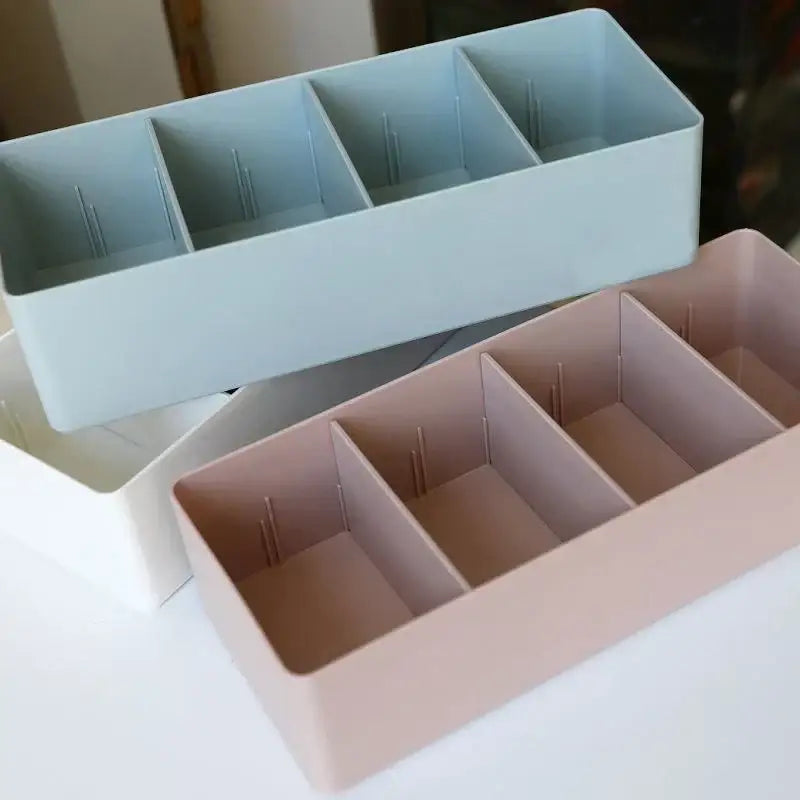 Pastel pink rectangular divided storage box with four compartments and internal dividers for kitchen tableware organization