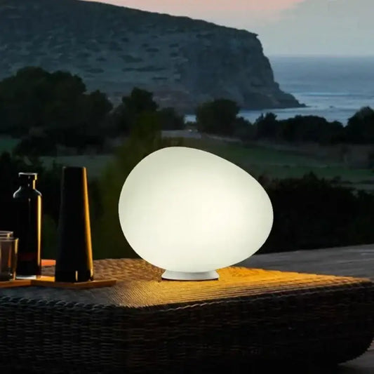 Minimalist white egg glass floor lamp with smooth translucent surface and soft glow for living room use