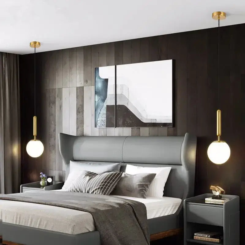 Gray upholstered wingback bed with tufted headboard and matching nightstands under minimalist white decorbites glass ball pendant light