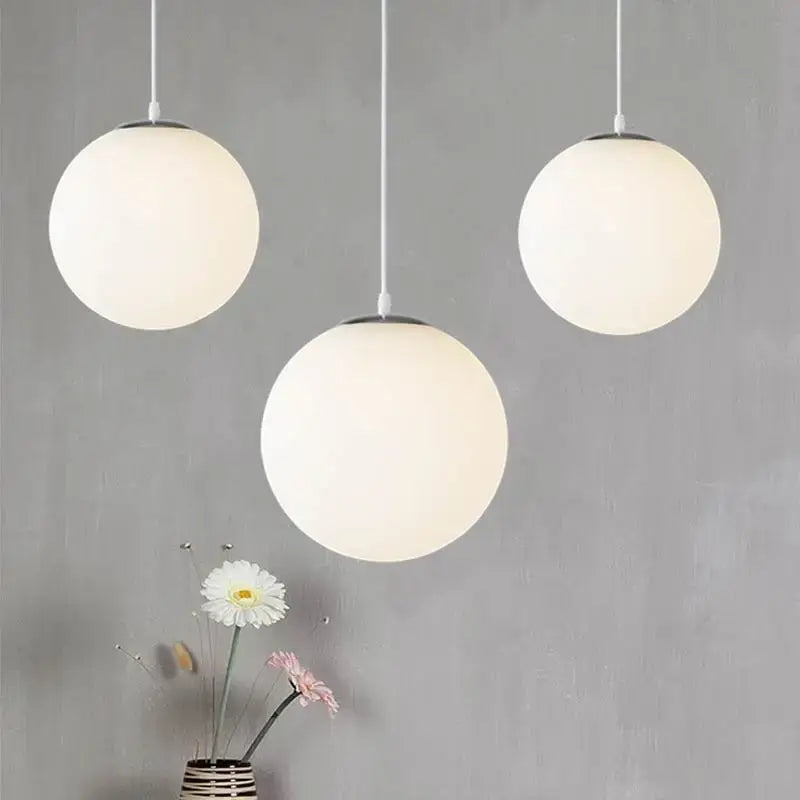 Minimalist white glass ball pendant lights with frosted glass shades and thin cords ideal for dining room decorbites glass ball