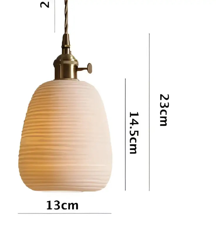 A warm-toned ribbed ceramic pendant light with brass fixture complementing minimalist white glass pendant lights