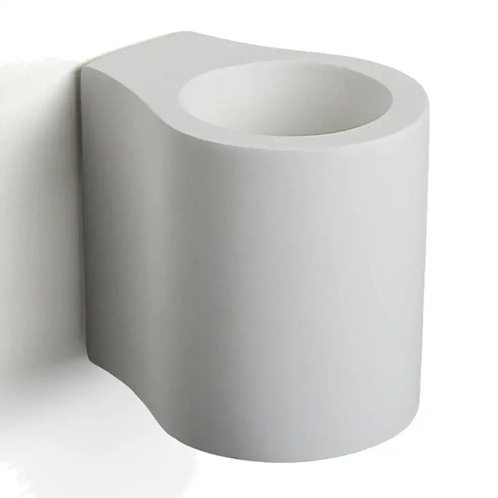 White ceramic wall-mounted toilet paper holder with sleek modern design complementing minimalist gypsum wall lamp