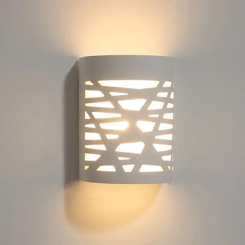 Minimalist white gypsum wall lamp with geometric cutout pattern providing diffused light for living room use