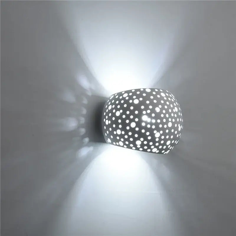 Minimalist gray ceramic gypsum wall lamp with circular holes casting diffused light for living room use