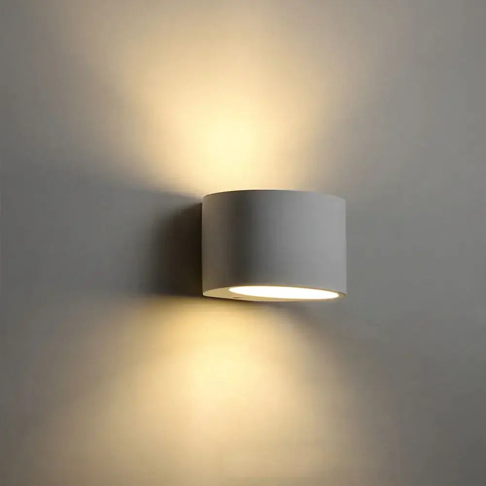 Minimalist white and gray gypsum wall lamp with warm diffused light designed as a cylindrical wall sconce for living room