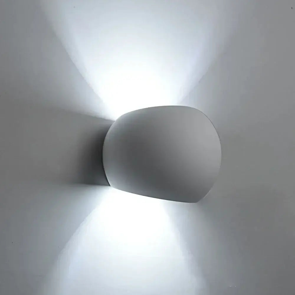 Modern minimalist white and gray gypsum wall lamp with a smooth rounded design for living room diffused light