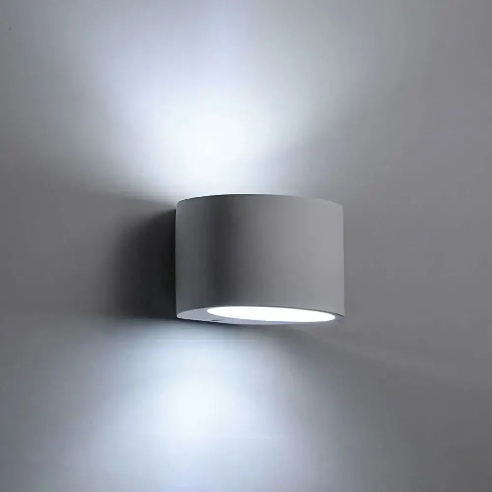 Minimalist white and gray gypsum wall lamp with cylindrical design provides diffused light for living room use