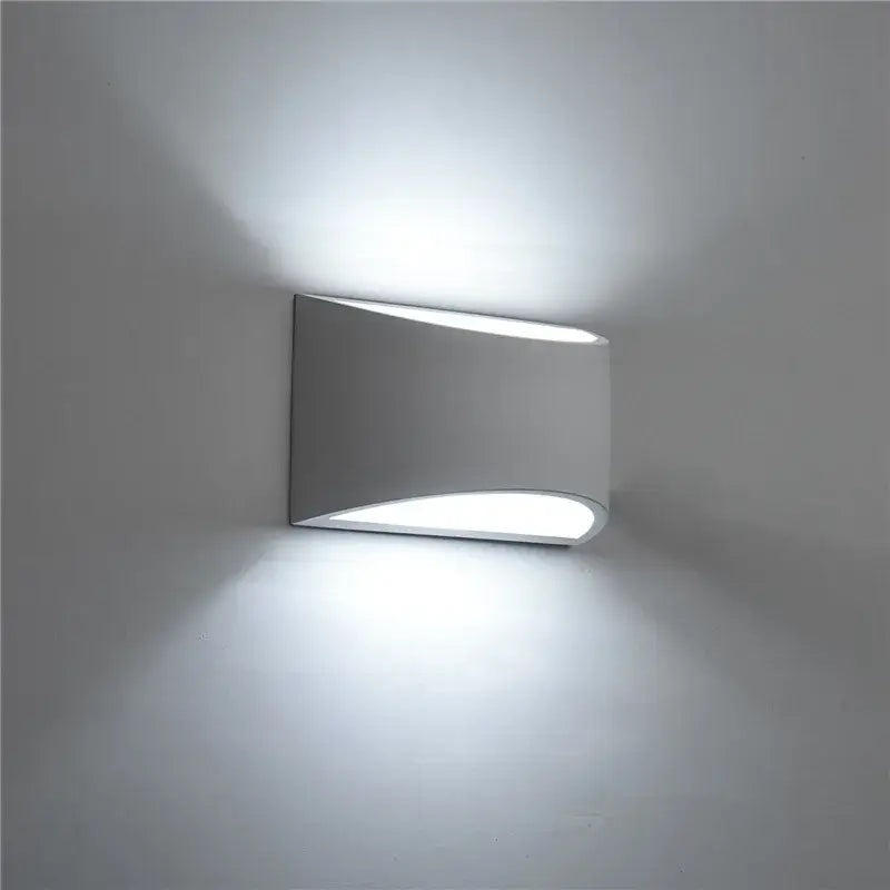Minimalist white and gray gypsum wall lamp with sleek curved design and frosted glass diffuser emitting soft white light