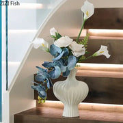 Minimalist white heart shape ceramic vase with vertical ridged texture holding blue orchids and white calla lilies decorbites heart shape