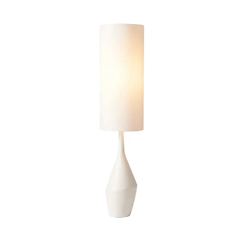 A sleek white ceramic led floor lamp with a sculpted faceted base and cylindrical soft-diffusing shade for living rooms