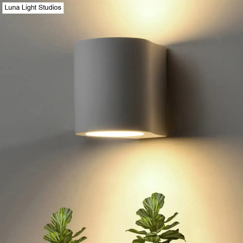 Modern matte gray cylindrical flush wall sconce wall lamp with warm focused light for minimalist bedroom use